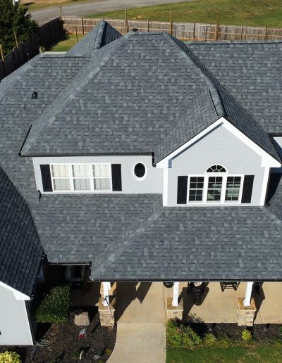 Charcoal shingle roof on large craftsman home with stone columns